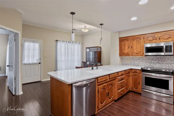 a kitchen with stainless steel appliances granite countertop a sink stove and wooden floor