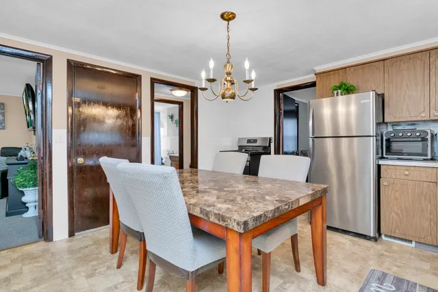 a kitchen that has a refrigerator a stove and a dining table