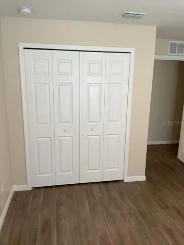 a view of a room with wooden floor and a window