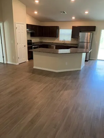 a view of kitchen with stainless steel appliances wooden floor