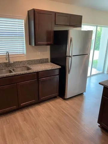 a kitchen with stainless steel appliances granite countertop a refrigerator and a sink
