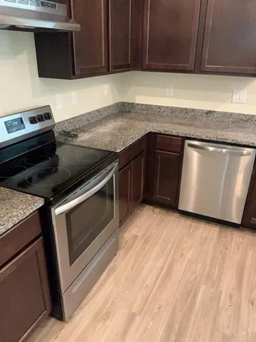 a kitchen with wooden cabinets and a stove top oven