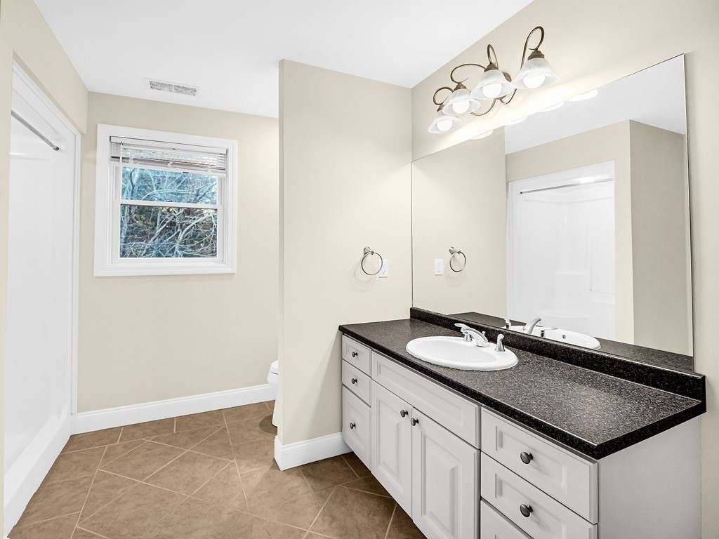 168 Proctor Road Chelmsford, MA 01824 - Photo 27 of 41 a bathroom with a granite countertop sink a large mirror and a shower