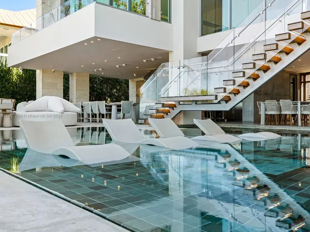 a view of a house with pool and chairs