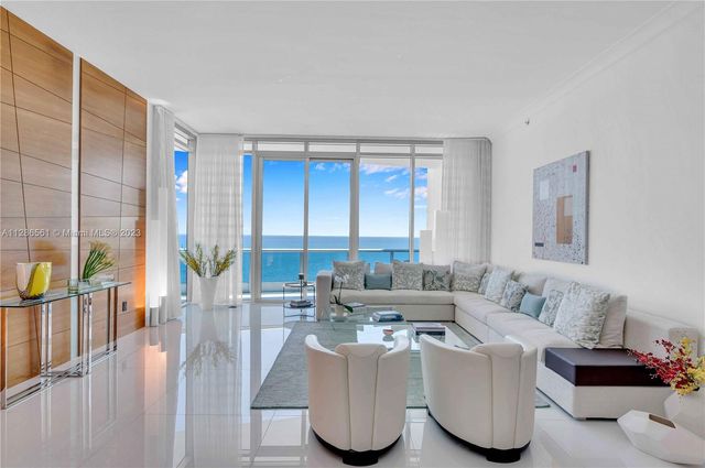 a living room with furniture and a floor to ceiling window