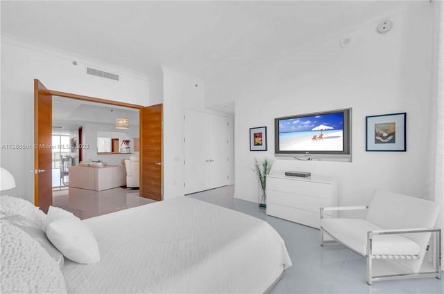 a bedroom with a large bed and a large window