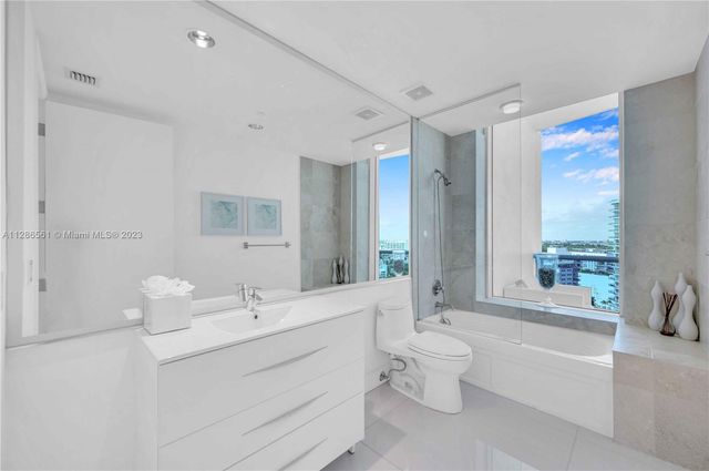 a bedroom with a bed potted plant on the dresser and floor
