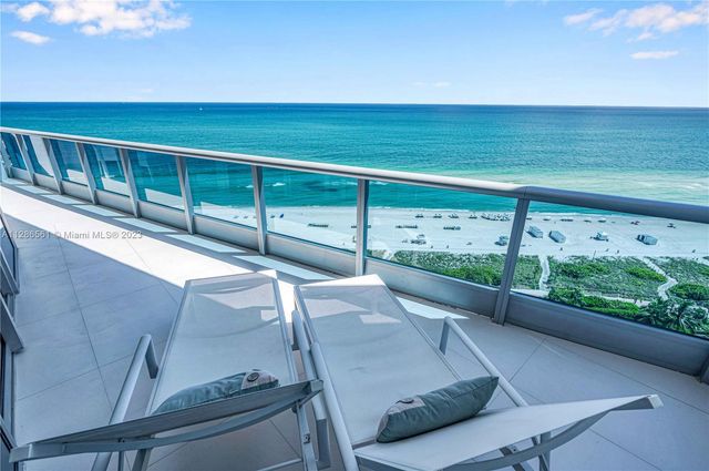 a view of a patio with lawn chairs floor to ceiling window and outdoor kitchen
