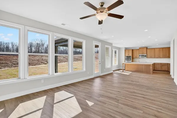 a view of an empty room with a window and wooden floor