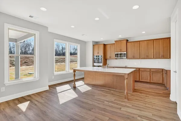 a large kitchen with kitchen island a large window a sink and a counter space