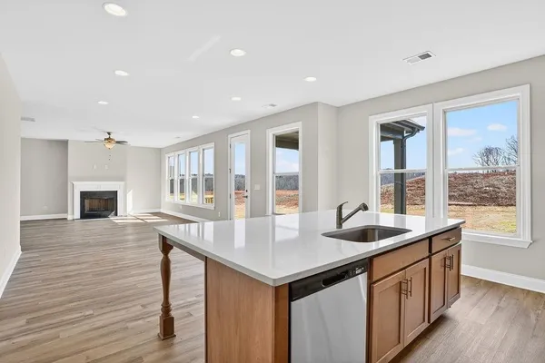 a kitchen with center island wooden floor and a sink