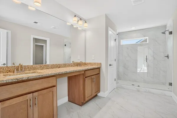 a bathroom with a granite countertop sink and a mirror