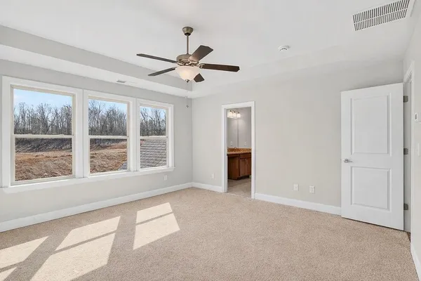 a view of a big room with windows and ceiling fan