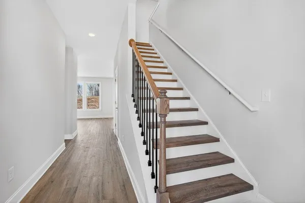 a view of a hallway with wooden floor and entryway