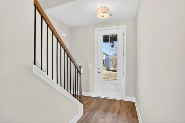 a view of a hallway with wooden floor and staircase
