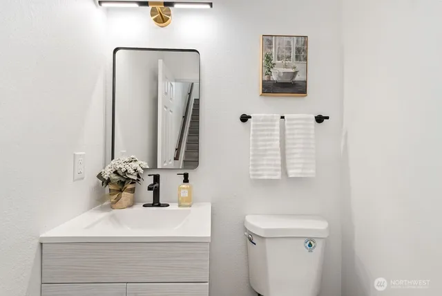 a bathroom with a sink a toilet and mirror
