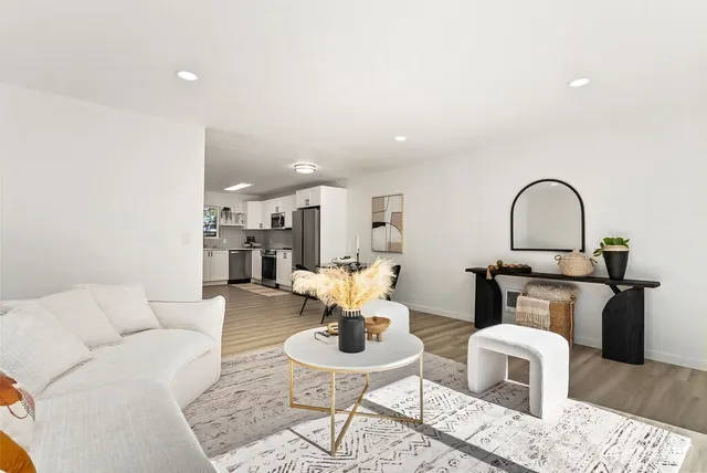 a living room with furniture a fireplace and kitchen view
