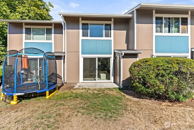 a front view of a house with glass windows and yard