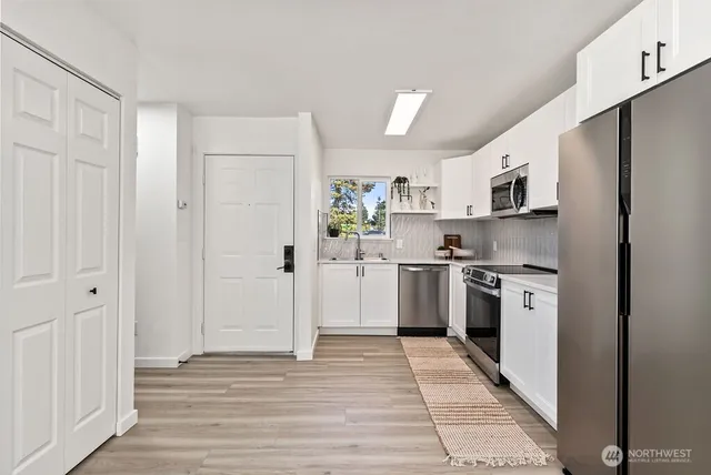 a kitchen with stainless steel appliances granite countertop a refrigerator sink and stove