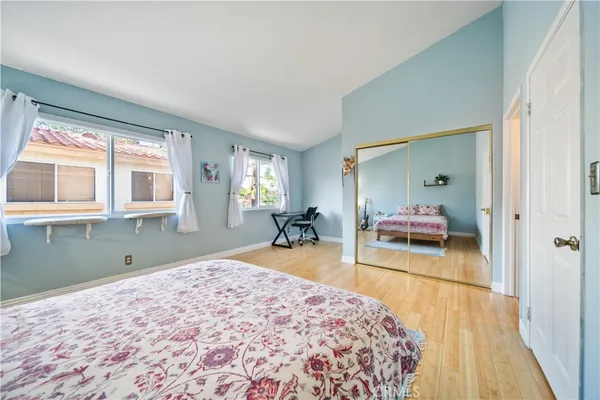a bedroom with a bed and a dresser next to a window