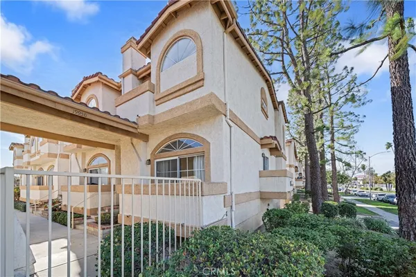 a view of a white house with a large windows and a large tree