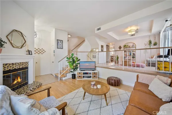 a living room with furniture a fireplace and a chandelier