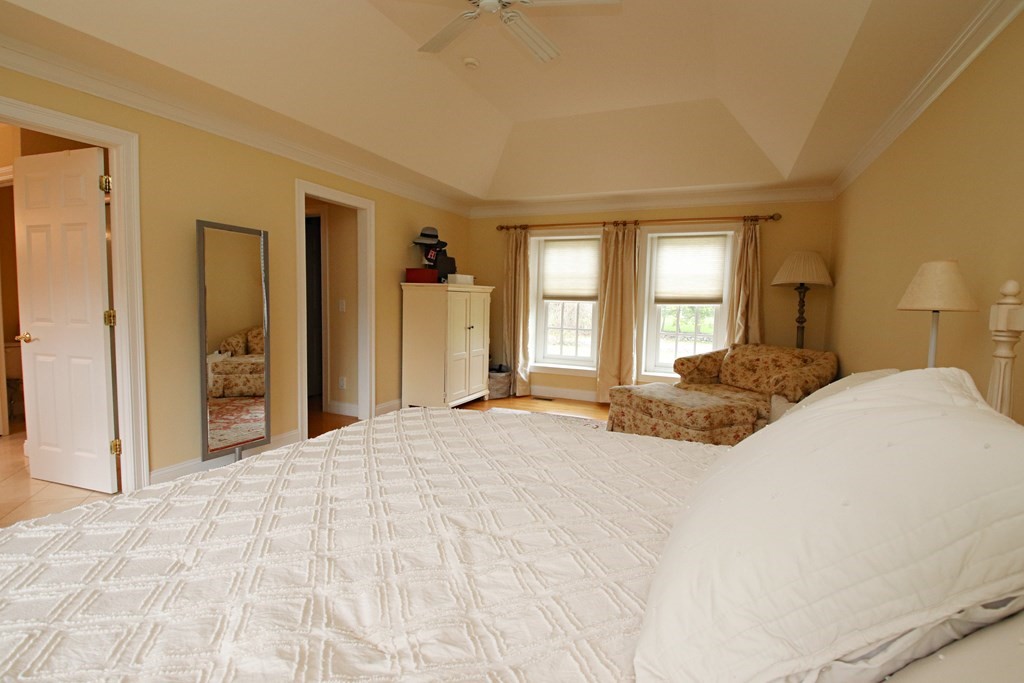 56 Main Street Boxford, MA 01921 - Photo 20 of 42 a large bed sitting in a spacious bedroom and a large mirror