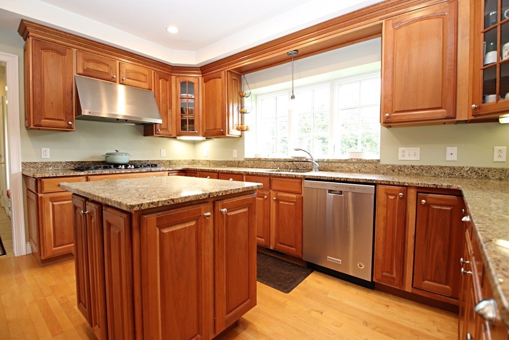 56 Main Street Boxford, MA 01921 - Photo 6 of 42 a kitchen with stainless steel appliances granite countertop wooden cabinets a sink and dishwasher with wooden floor