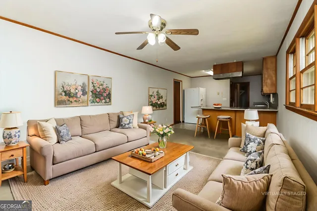 a living room with furniture a ceiling fan and a window