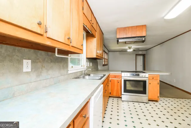 a kitchen with stainless steel appliances a stove a sink and a microwave