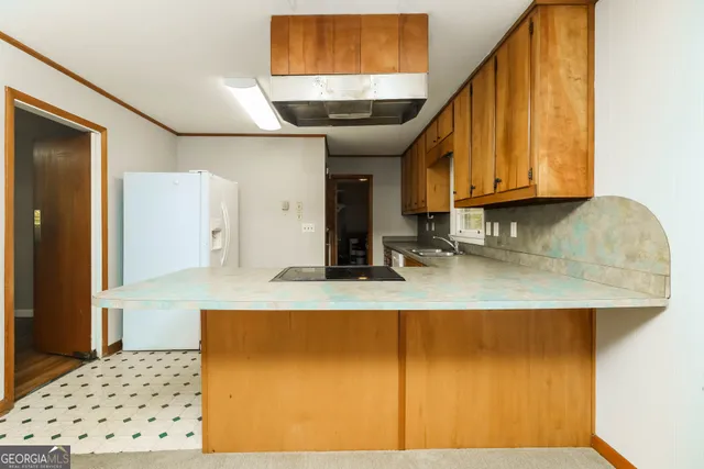 a kitchen with granite countertop a sink a stove and cabinets