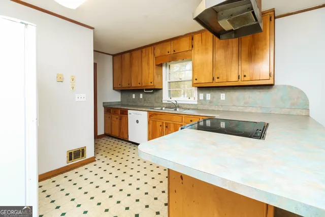 a kitchen with granite countertop a sink a stove and a microwave