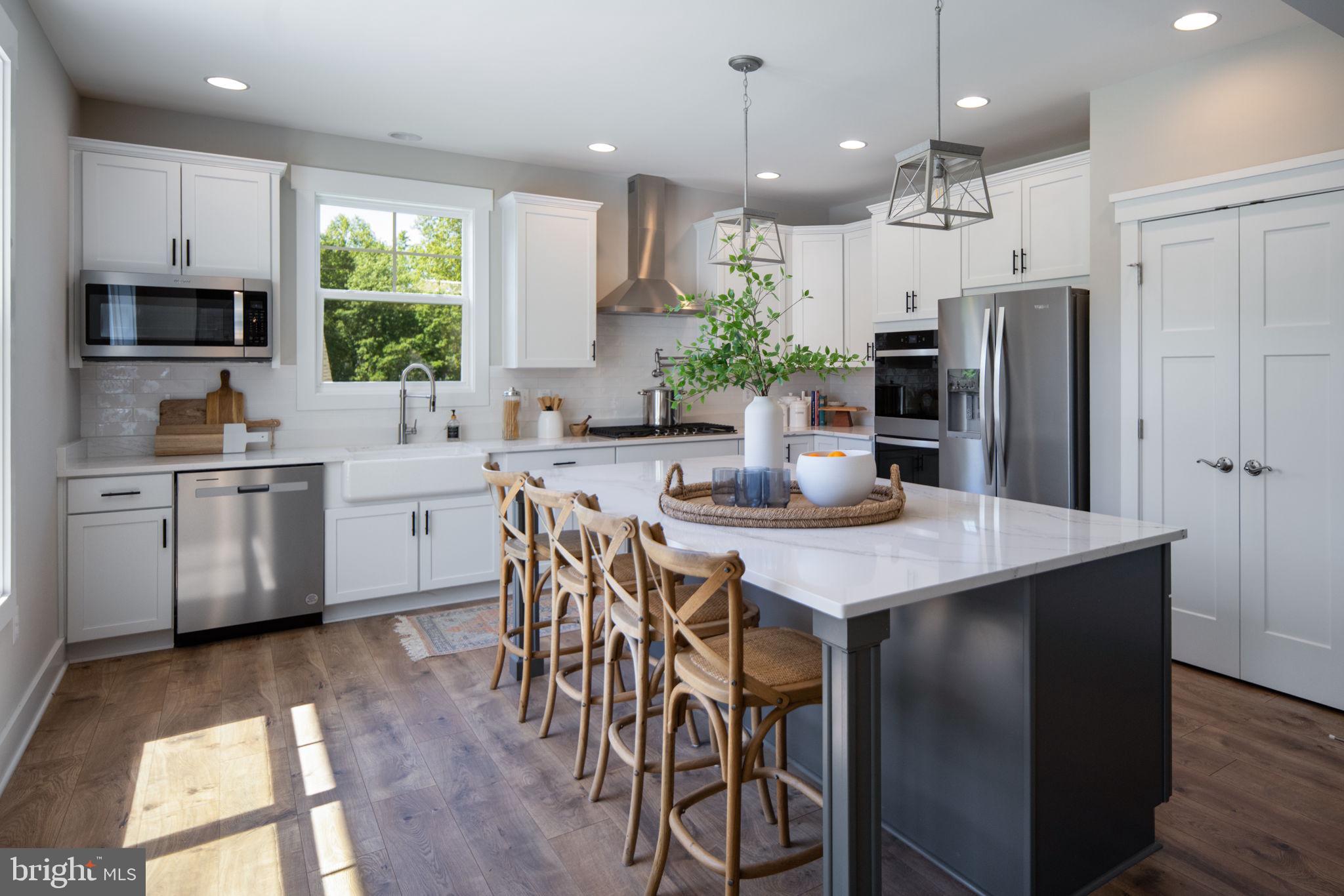 119 Juggins Road Stafford, VA 22556 - Photo 16 of 46 a kitchen with stainless steel appliances kitchen island granite countertop a sink a stove a refrigerator cabinets and a dining table with wooden floor
