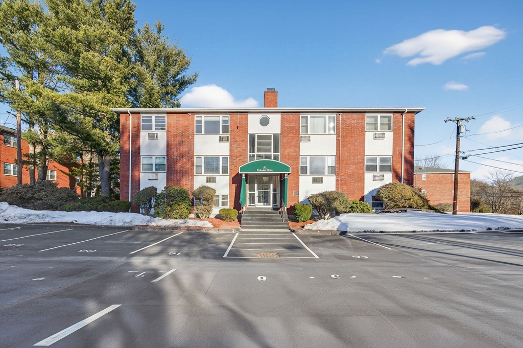 A1 Colonial Drive, Unit 10 Andover, MA 01810 - Photo 18 of 18 a view of a brick house with large windows and a table