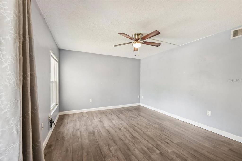610 Cranes Way, Unit 207 Altamonte Springs, FL 32701 - Photo 13 of 27 an empty room with wooden floor and a ceiling fan