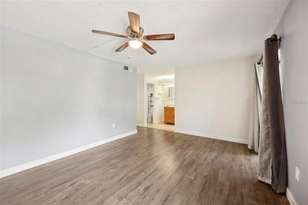 610 Cranes Way, Unit 207 Altamonte Springs, FL 32701 - Photo 14 of 27 an empty room with wooden floor fan and windows