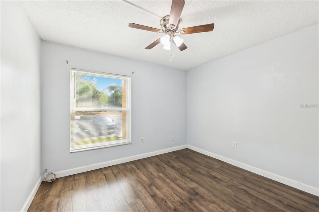 610 Cranes Way, Unit 207 Altamonte Springs, FL 32701 - Photo 8 of 27 an empty room with wooden floor chandelier fan and windows