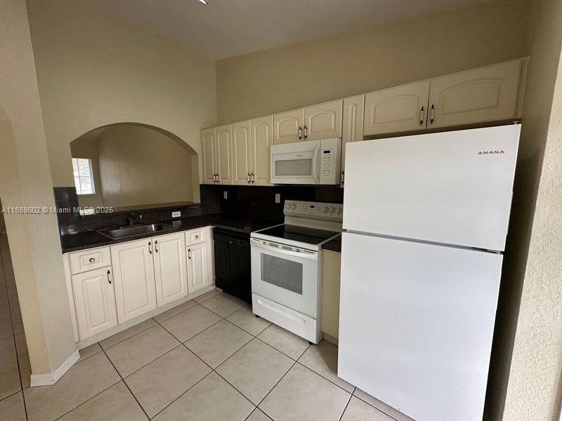1260 Southeast 29th Street, Unit 20359 Homestead, FL 33035 - Photo 4 of 19 a kitchen with cabinets and white appliances
