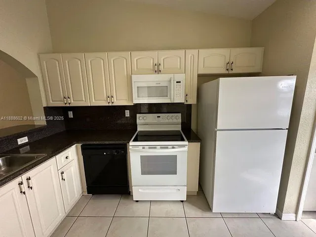 a kitchen with a refrigerator sink stove and cabinets