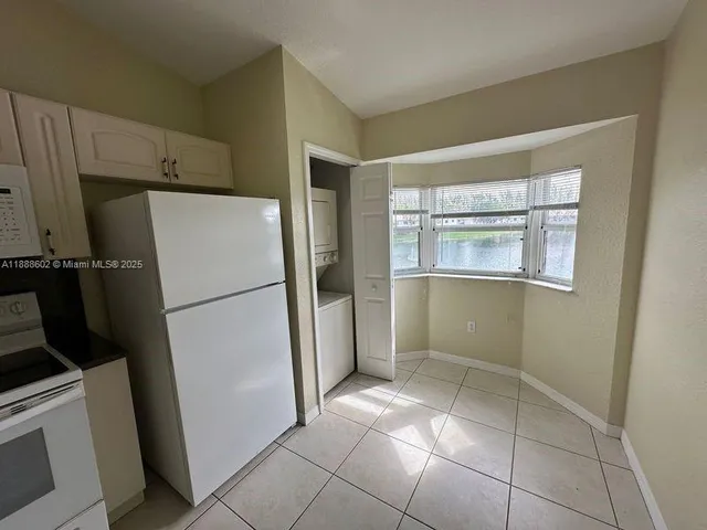 a view of a kitchen with refrigerator and cabinet