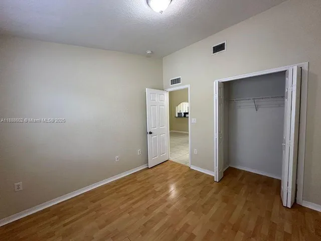 an empty room with wooden floor and bathroom