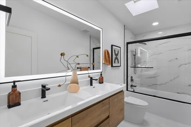 a bathroom with a sink a toilet and shower