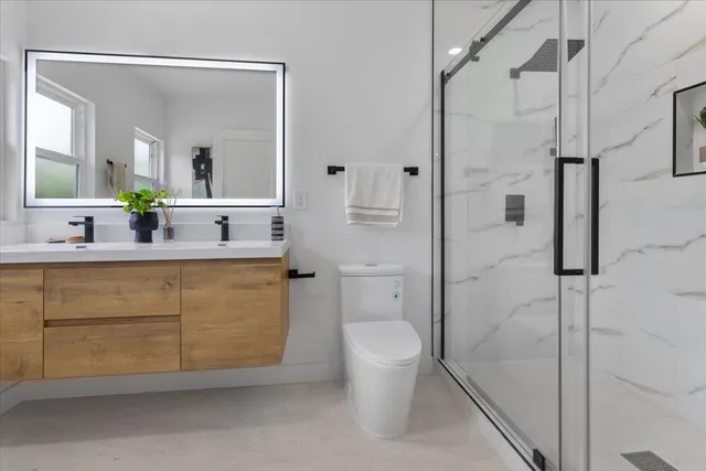 a bathroom with a granite countertop sink mirror vanity and toilet