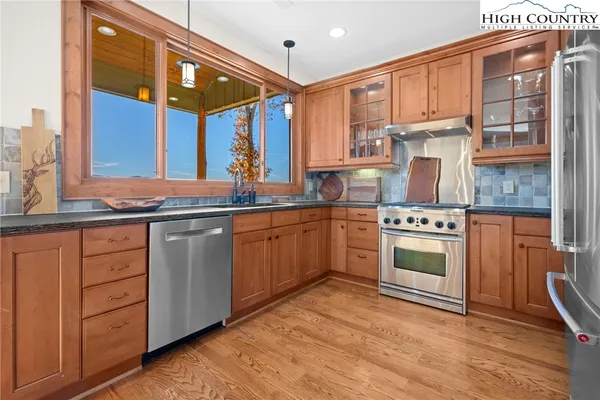 a kitchen with stainless steel appliances granite countertop a stove a sink and a refrigerator