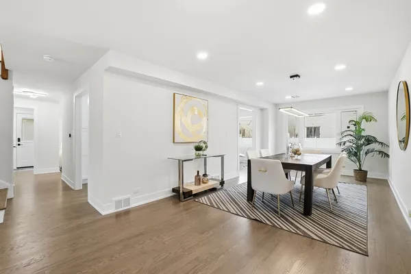 a living room with furniture a wooden floor and a potted plant