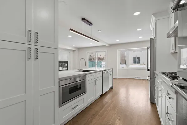 a kitchen with counter top space a sink stainless steel appliances and cabinets
