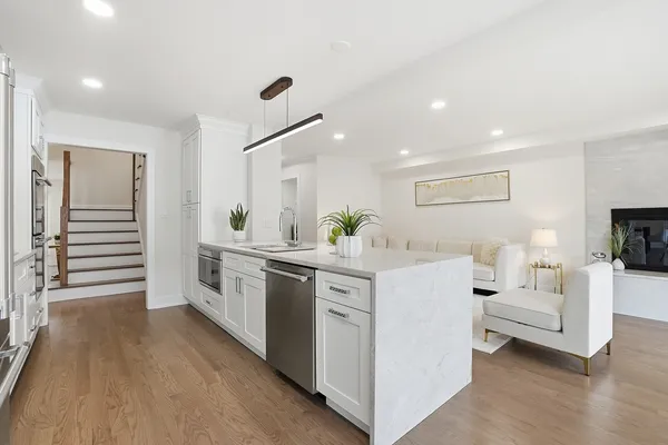 a large white kitchen with lots of counter space and stainless steel appliances