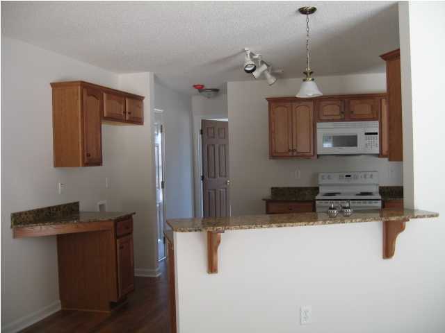 5216 Moore Loop Crestview, FL 32536 - Photo 4 of 5 a kitchen with stainless steel appliances kitchen island granite countertop a refrigerator a sink and a stove