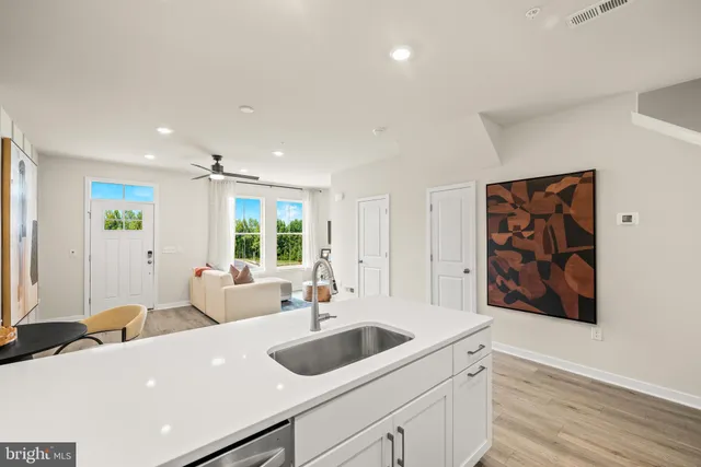 a view of a kitchen island a sink furniture a window and a wooden floor