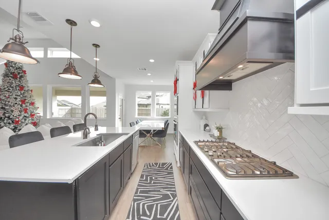 a kitchen with sink stove and cabinets